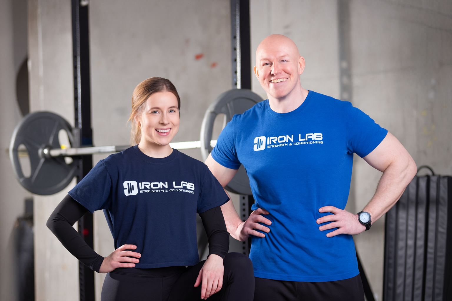 Female personal trainer Charlotte standing and smiling with male head trainer Martin
